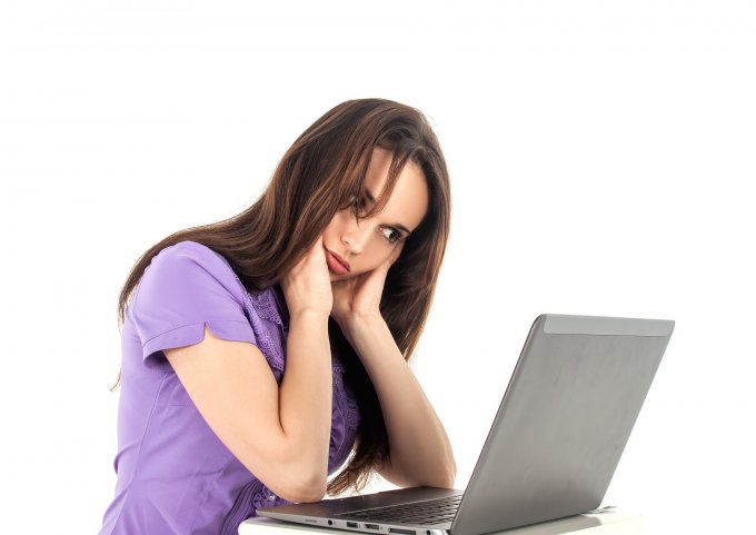 zmęczona kobieta siedząca przy laptopie